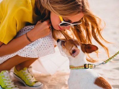 young-stylish-hipster-woman-holding-walking-and-playing-with-dog-in-tropical-park-smiling-and-have-fun-800x1200